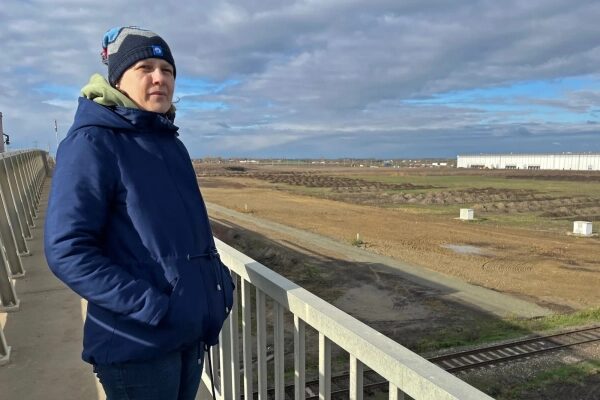 Экологические издержки и последствия для прав человека инвестиций Китая в чистую энергетику за рубежом. 2 Эва Козма смотрит на индустриальный парк, в котором расположен кластер заводов по производству аккумуляторов в Дебрецене.