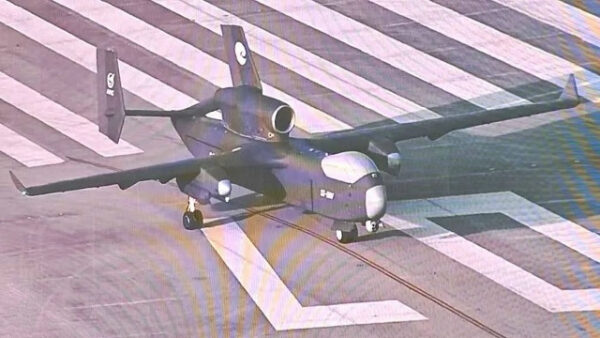 Беспилотник на взлетной полосе в аэропорту, вид сверху, солнечный день.