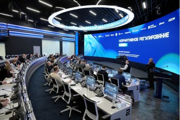 Конференция по нормативному регулированию в технологическом центре с большим экраном.