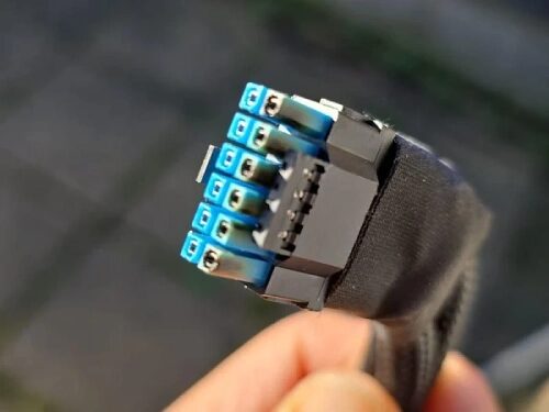 Кабель питания EPS зажат в руке, показан крупным планом на фоне улицы.