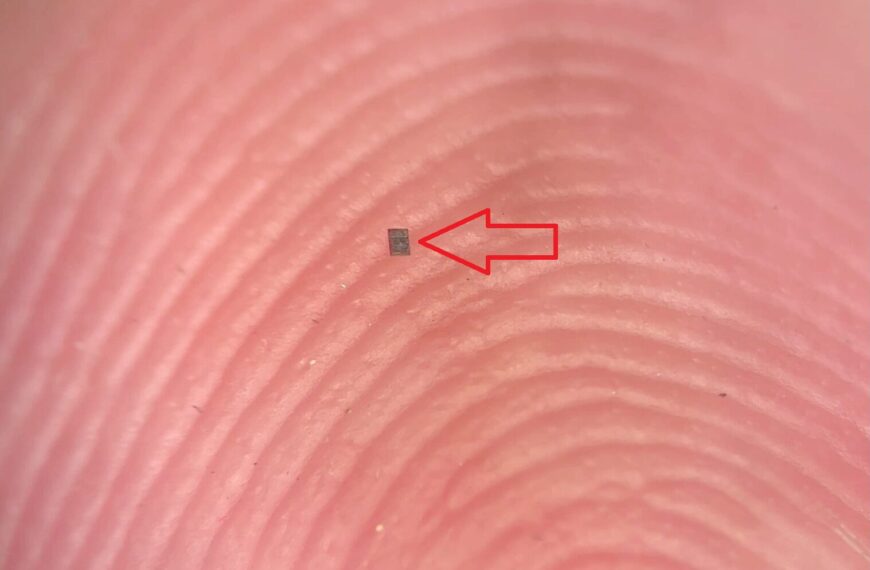 Палец с микроскопическим чипом, увеличенный, на отпечатках пальцев красная стрелка.