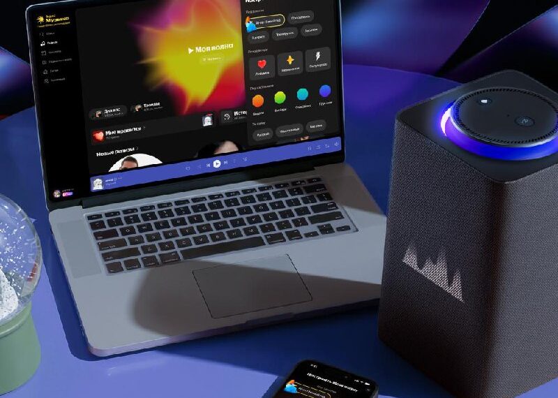 Ноутбук, смартфон и колонка на столе, демонстрирующие музыкальное приложение.