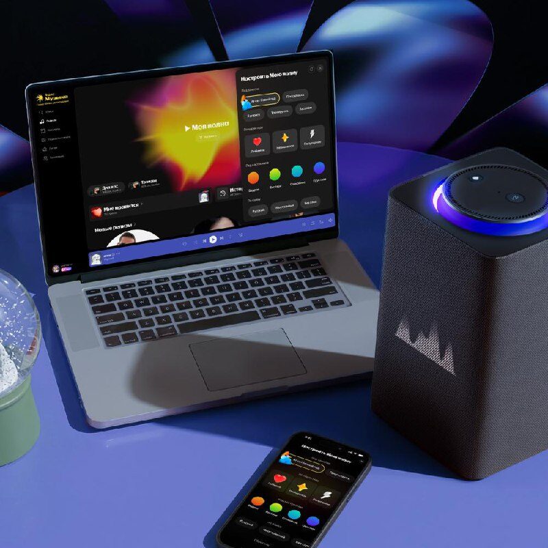 Ноутбук, смартфон и колонка на столе, демонстрирующие музыкальное приложение.