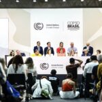 Конференция ООН по климату COP30 в Амазонии, Бразилия, 2030 год, участники за круглым столом.