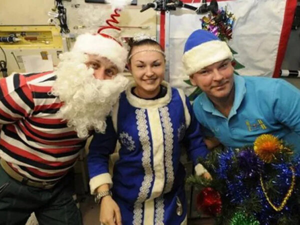 Новогодние костюмы Деда Мороза и Снегурочки с праздничными украшениями и ёлкой.