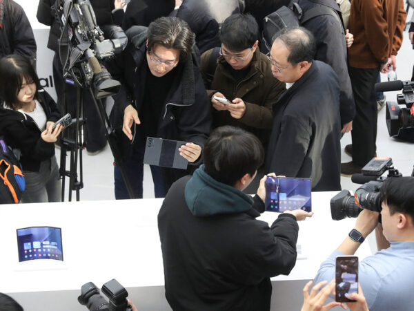 Люди изучают новые складные смартфоны на презентации.