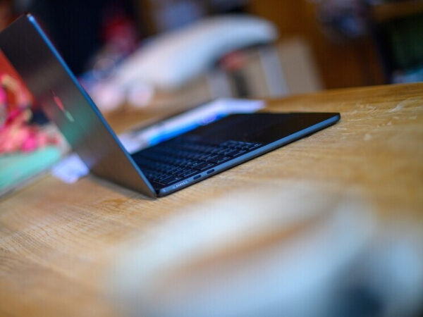 Открытый ноутбук на деревянном столе в уютной обстановке.