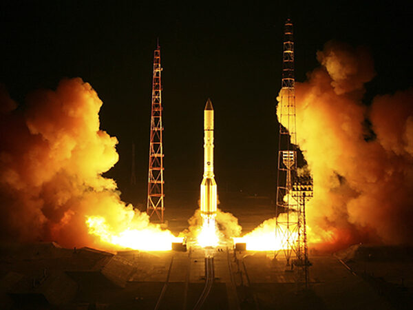 Запуск ракеты ночью с космодрома, пламя и дым при старте.