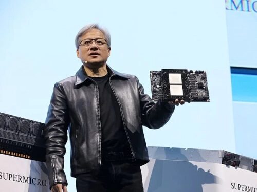 Человек в кожаной куртке демонстрирует компьютерную плату на выставке Supermicro.