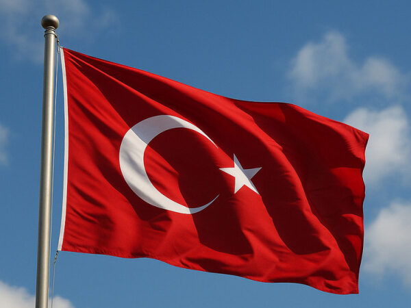 Флаг Турции на ветру на фоне голубого неба.