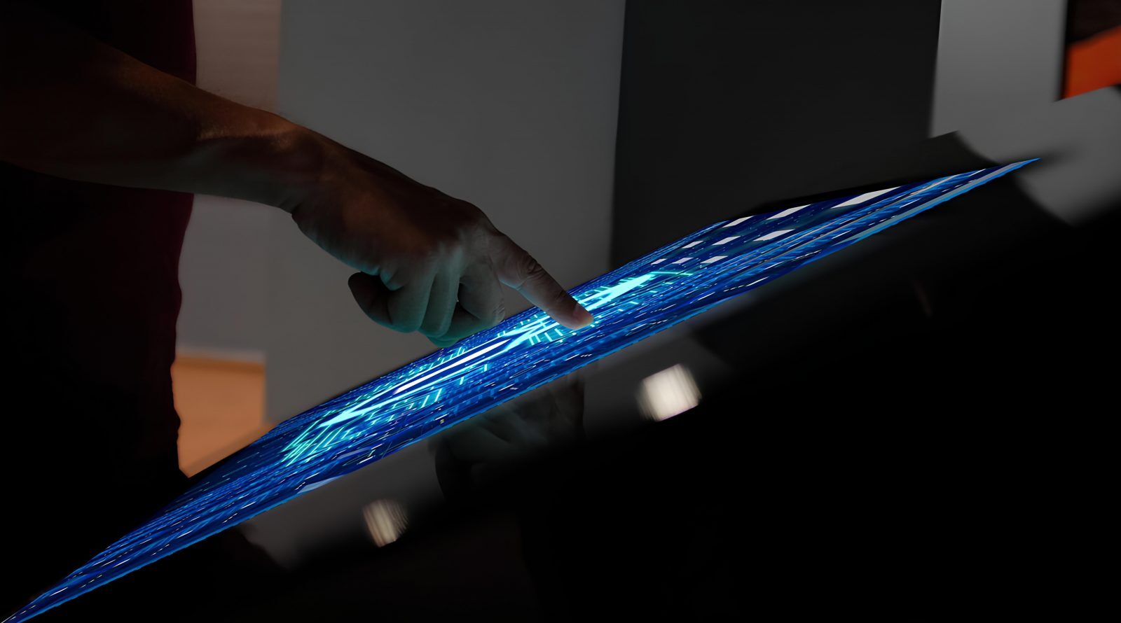 От картинки к ощущению: тактильные дисплеи нового поколения 2 Рука касается голографического дисплея с синими световыми линиями.