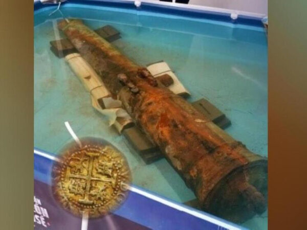 Старинная пушка в воде, вид сверху, рядом изображение старинной монеты.