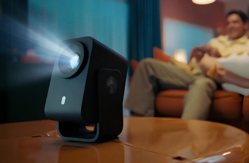 Компактный проектор на столе в уютной комнате с мягким освещением.