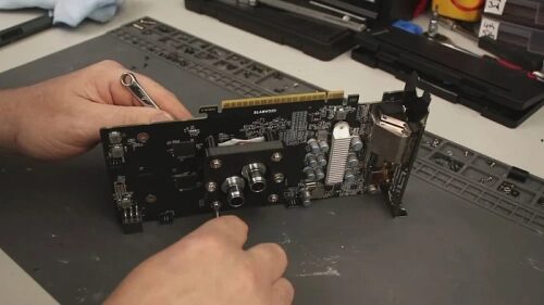 Ремонт или сборка компьютерной звуковой платы с помощью отвертки.