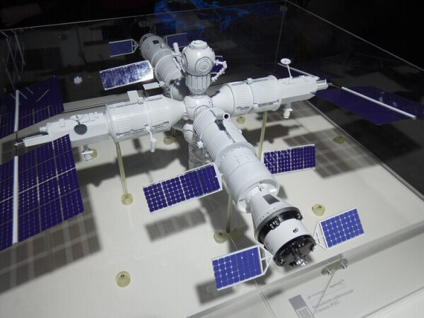 Макет космической станции с солнечными панелями на выставке.