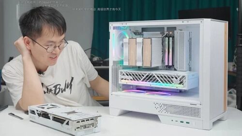 Компьютер в белом корпусе с RGB-подсветкой и разобранной видеокартой на столе.