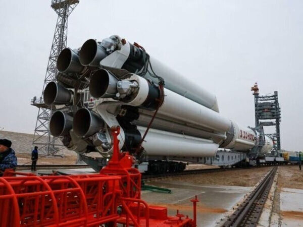 Ракета на стартовой площадке космодрома, вид сбоку, готовится к запуску.