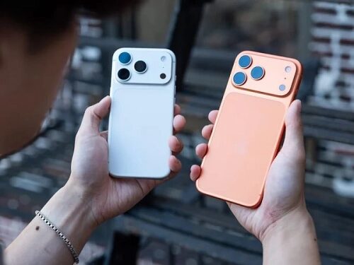 Два смартфона с тремя камерами в руках: белый и оранжевый.