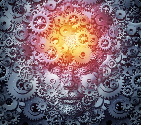 Зубчатые колеса формируют силуэт человека, символизируя мышление и инновации.