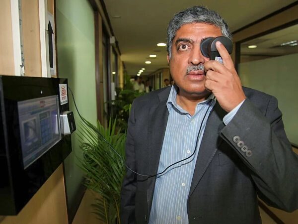 Человек, который сделал Индию цифровой страной, еще не закончил свою работу. 2 Нилекани подносит устройство к одному глазу.