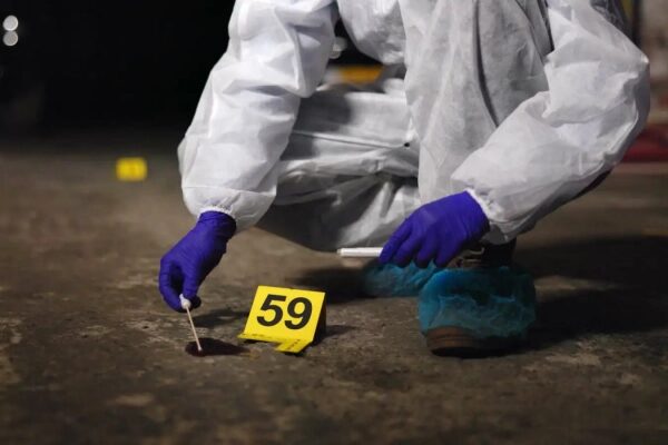 Эксперт в защитном костюме собирает улики на месте преступления, метка 59.