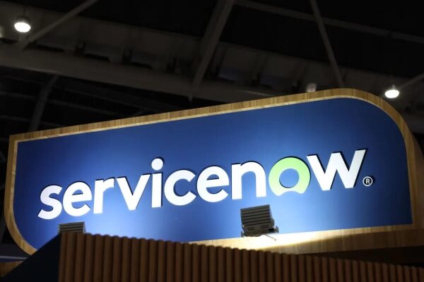 ServiceNow заключает еще одно партнерство в области искусственного интеллекта, на этот раз с компанией Anthropic. 2 Логотип ServiceNow на синем фоне, освещение выставочного стенда, крупный план.