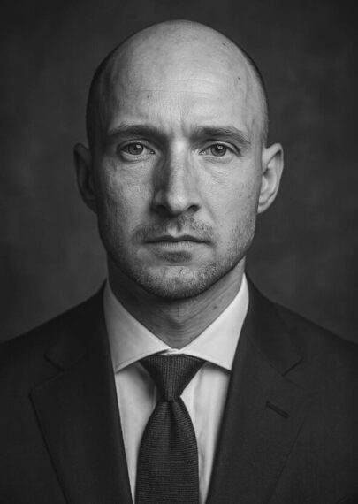 Человек в классическом костюме и галстуке, черно-белая фотография, студийный портрет.