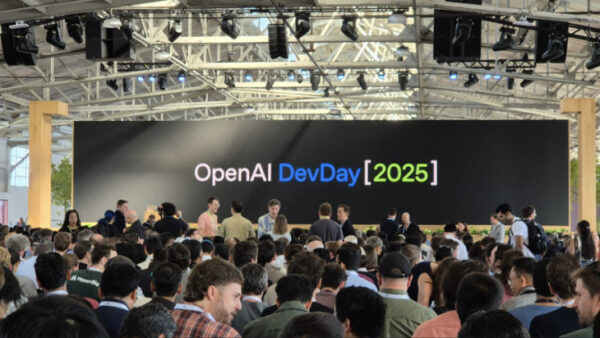 Конференция OpenAI DevDay 2025, люди обсуждают на фоне экрана с логотипом.