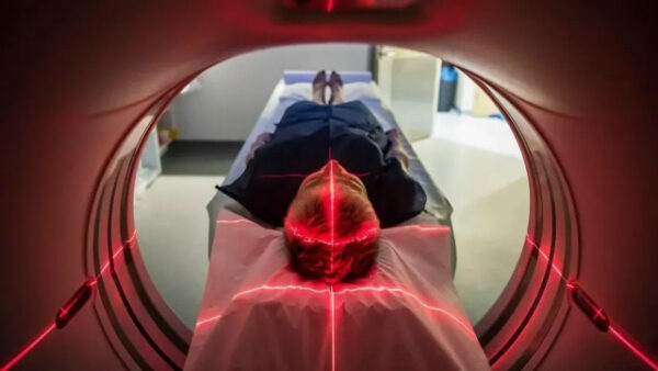 Пациент в аппарате МРТ, видны направленные лазеры для точной диагностики.