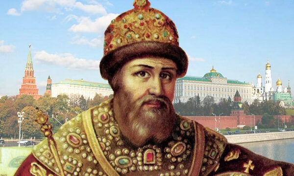 Историческая фигура в царской одежде на фоне Кремля и голубого неба.