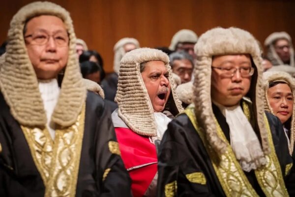 Судьи в париках и церемониальных мантиях на официальном мероприятии.