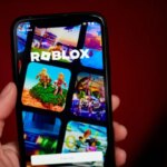 Смартфон с открытым приложением Roblox на экране, крупный план руки.