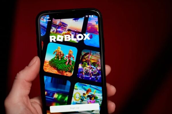 Смартфон с открытым приложением Roblox на экране, крупный план руки.