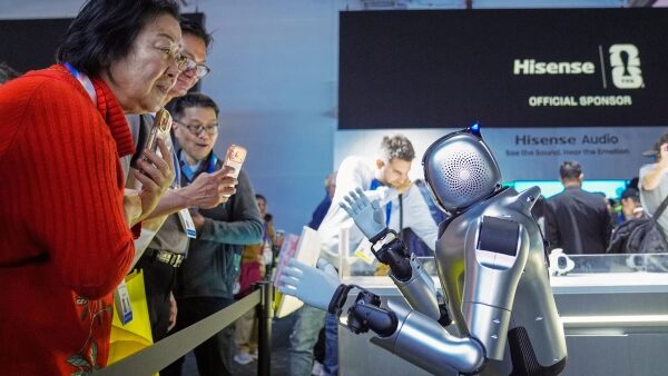 Посетители выставки общаются с роботом на стенде Hisense.