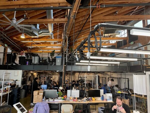 Современный офис с открытой планировкой, сотрудники работают за компьютерами.