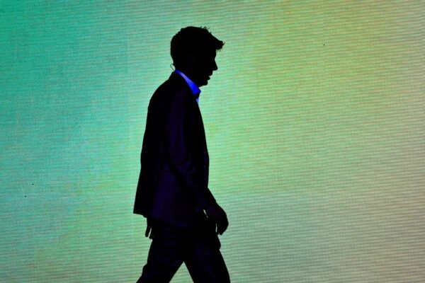 Силуэт мужчины в костюме на фоне градиентного экрана.