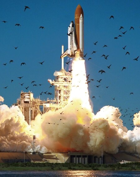 Запуск космического шаттла, взлёт ракеты на фоне голубого неба и птиц.