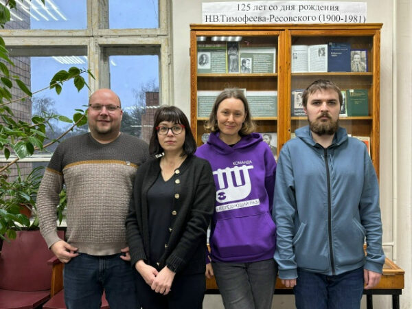 Группа людей перед стендом, посвящённым 125-летию Н.В. Тимофеева-Ресовского.