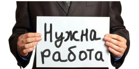 Мужчина в костюме держит табличку "Нужна работа".
