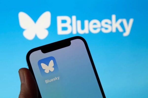 Логотип приложения Bluesky на экране смартфона на фоне логотипа.