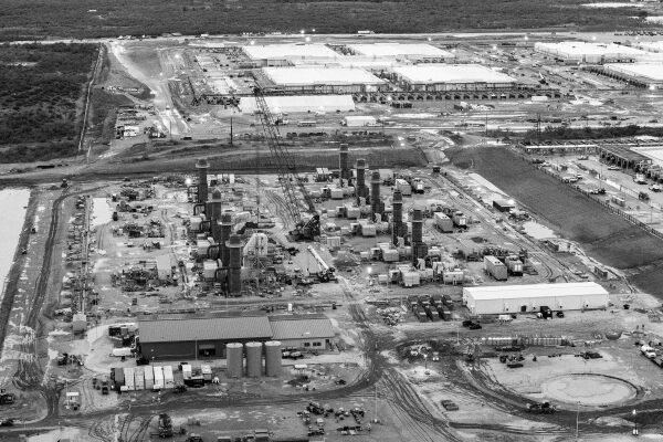 Центры обработки данных стимулируют газовый бум в США. 2 Строительство комплекса с башнями и зданиями, вид сверху, чёрно-белое фото.