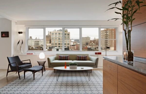 Современная гостиная с видом на город через панорамные окна, стильная мебель и декор.