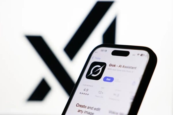 Смартфон с открытым приложением "Grok - AI Assistant" на фоне черно-белого логотипа X.