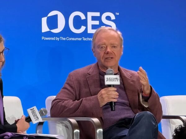 Панельная дискуссия на CES 2023, мужчина с микрофоном от Variety на фоне логотипа CES.