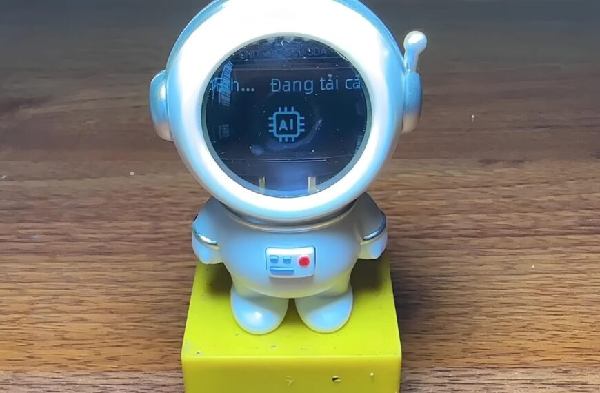 Фигурка астронавта с экраном, показывающим загрузку AI, стоит на деревянной поверхности.