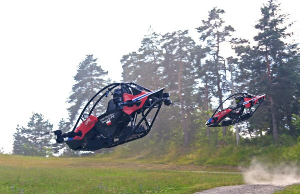 Летающие ховербайки над землей на фоне леса и неба. Инновационный транспорт будущего.