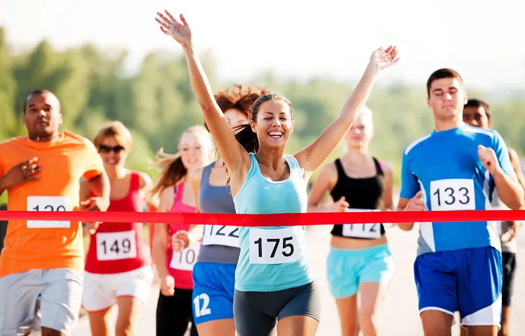 Большие цели могут казаться непосильными. Вот как не сбиться с пути 3 женщина, как она пересекает финишную черту гонки, руки в воздух, и она сияет от счастья.