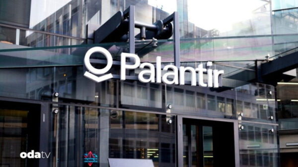Вход в офис Palantir с логотипом на стеклянной фасадной стене.