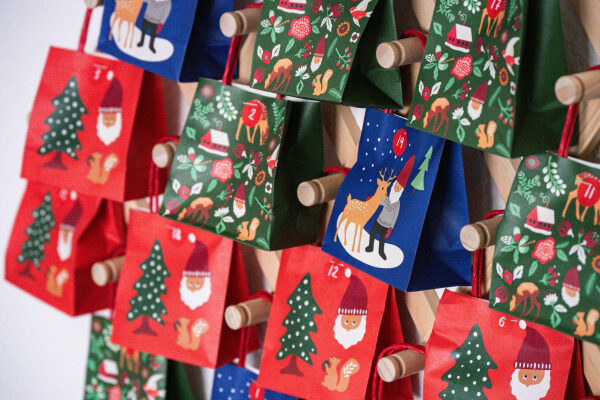 Адвент-календарь с подарками и новогодними рисунками на стене.