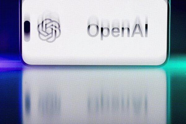 Логотип OpenAI на экране смартфона с размытым отражением на фоне.